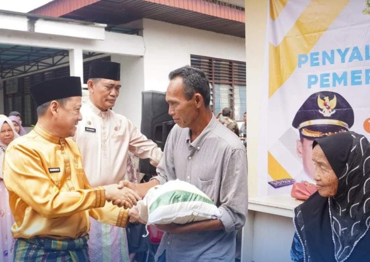 Pj Bupati Kampar Salurkan Cadangan Beras kepada Keluarga Penerima Manfaat di Desa Kuok